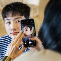 Một tình nguyện viên của Apple sử dụng một chiếc iPhone để hỗ trợ chụp ảnh với chương trình Creative Studios ở Tokyo.