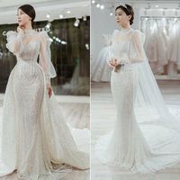 Váy cưới 2 trong 1 của cô dâu Cẩm Tú có dáng đuôi cá cơ bản và tà phụ giúp cô dâu biến hóa linh hoạt giữa các phong cách. Thiết kế đính kết họa tiết 3D lấy cảm hứng từ đường diềm kiến trúc Phục Hưng. Cẩm Tú cho biết cô cùng ekip đã dành 2 năm để bàn bạc về ý tưởng và hoàn thiện tất cả các công đoạn làm nên chiếc váy. Bởi váy cưới không chỉ đơn giản là một bộ lễ phục mà còn thể hiện tính cách, tâm hồn của người chủ sở hữu nên Cẩm Tú đã cảm thấy vô cùng xúc động ngay trong lần thử váy đầu tiên.