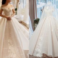 Váy cưới trễ vai thời thượng của cô dâu Ngân Đặng có độ xòe vừa phải để phù hợp với không gian tiệc cưới trong phòng và giúp cô dâu dễ dàng di chuyển. Độ bắt sáng (lấp lánh) của váy có chiều sâu nhờ layer phía trong được làm bằng chất liệu ren nhập Pháp cao cấp.