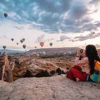 Cô gái nhiếp ảnh gia du lịch chụp ảnh khinh khí cầu khi mặt trời mọc ở Cappadocia