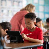 Một học sinh nhỏ tuổi tại Học Khu Thống Nhất Downey đang sử dụng iPad trong lớp học.