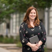 Jennifer Robbins, giám đốc giáo dục tiểu học của Học Khu Thống Nhất Downey kiêm vai trò Apple Learning Coach, đang cầm iPad đứng ngoài trời.