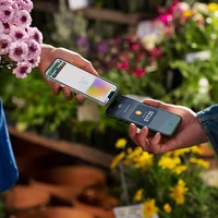 Một người đang dùng Tap to Pay on iPhone để thanh toán cho một người dùng iPhone khác.