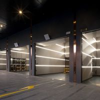 Khu garage xe siêu sang bao gồm 10 chỗ đậu xe với nội thất cao cấp, trạm sạc xe điện và cửa cuốn nhìn xuyên thấu.