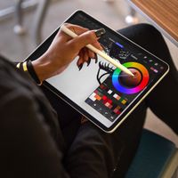 Ảnh cận cảnh màn hình iPad Pro, nơi Liza đang sử dụng Procreate và Apple Pencil.