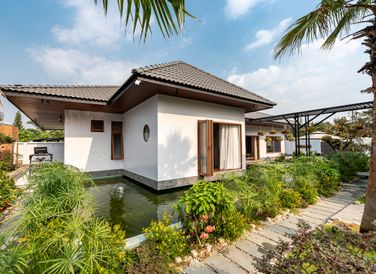 Nhà vườn có quy mô một tầng, mái ngói, được xây dựng trên khu đất rộng 1.300 m2 tại Tây Ninh, là nơi sinh sống của một cặp vợ chồng và hai con.