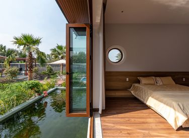 Phòng ngủ chính với tầm nhìn hướng thẳng ra sân vườn và hồ cá koi.