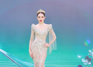 Á hậu 3 Hồng Hạnh gây chú ý với phần cầu vai nối dài đến chi tiết tua rua lãng mạn. Chiếc váy xuyên thấu được trang trí hoàn toàn bằng kỹ nghệ đính kết.