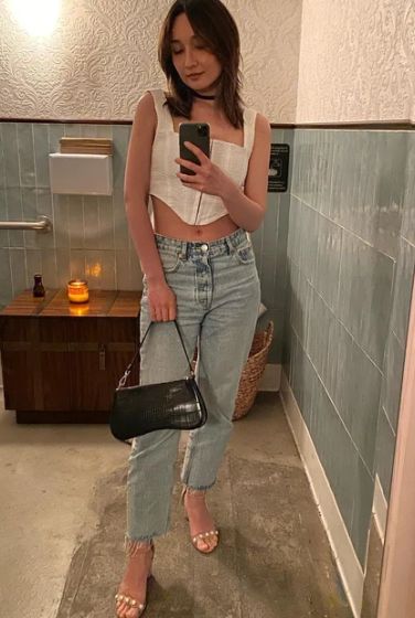 Anna Trương ghi điểm ở sự cá tính xen lẫn nét quyến rũ khi diện áo corset với quần jeans ống đứng. Tổng thể trang phục trở nên thời thượng hơn khi Anna Trương diện vòng choker và mang túi xách quai ngắn. Đôi sandal quai ngang Anna Trương chọn rất phù hợp với bộ trang phục phóng khoáng. Mẫu giày này còn mang đến hiệu quả tôn dáng tối ưu.