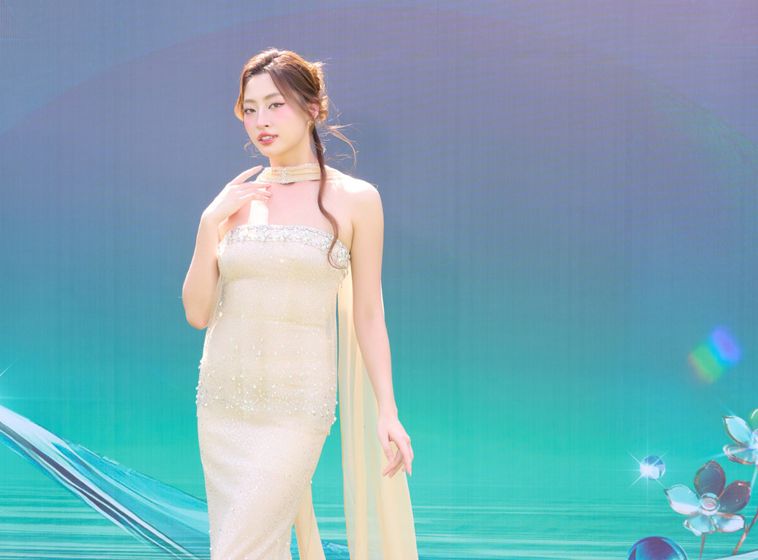 Hoa hậu Lương Thùy Linh măc váy quây, kèm theo phần tà dài đến từ khăn cổ. 