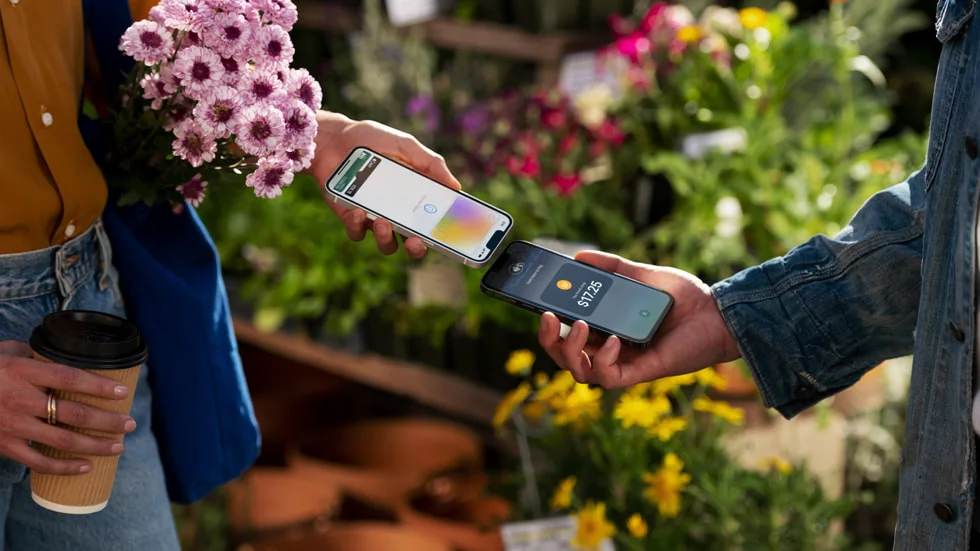 Một người đang dùng Tap to Pay on iPhone để thanh toán cho một người dùng iPhone khác.