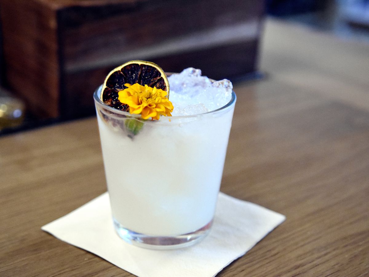 Pale white cocktail with dried blood orange and marigold. 
