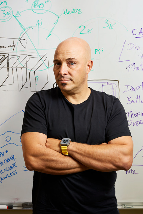 Phó giám đốc Phát triển và Thiết kế sản phẩm của Huish Outdoors, Andrea Silvestri, và thiết kế đứng trước một chiếc bảng trắng.