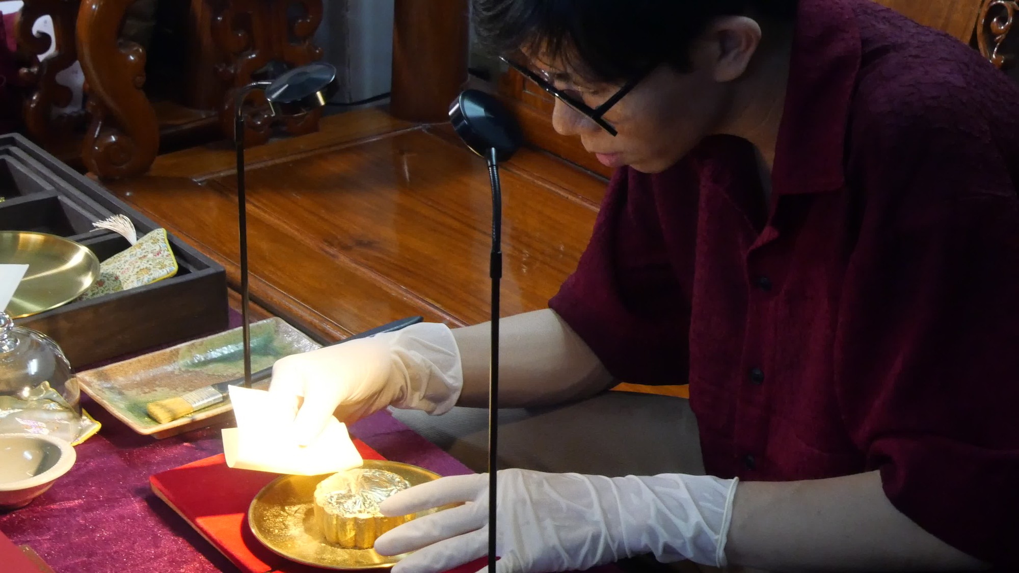 Quá trình dát vàng lên bánh trung thu cần sự tỉ mỉ và khéo léo (Ảnh: Xuân Nghiệp)