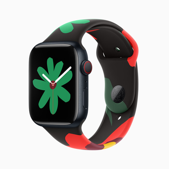 Hình ảnh Apple Watch Series 9 với dây đeo trong Bộ Sưu Tập Black Unity và mặt đồng hồ mới; trong hình ảnh này, mặt đồng hồ có một bông hoa màu xanh lá nhỏ hơn.